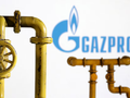 Mô hình đường ống dẫn khí đốt tự nhiên và logo của tập đoàn Gazprom. Ảnh: Reuters.