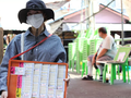 Một người bán vé số tại đường Ti Thong ở Bangkok, Thái Lan. Ảnh: Bangkok Post.