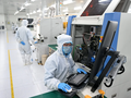 Nhân viên làm việc tại một xưởng sản xuất chip ở tỉnh Hà Bắc, miền Bắc Trung Quốc. Chính quyền địa phương Trung Quốc đang đổ tiền đầu tư vào lĩnh vực bán dẫn trong bối cảnh cạnh tranh để vươn lên trở thành siêu cường sản xuất chip. Ảnh: Xinhua.