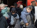 Người tị nạn từ Ukraine đứng cạnh một chiếc xe buýt tại trung tâm tiếp nhận người tị nạn đầu tiên ở Hesse, Đức. Ảnh: Getty.