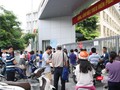 Phụ huynh học sinh đứng chờ con ở điểm thi. Ảnh: Minh Thúy
