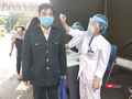 Nhân viên y tế đo nhiệt độ cho người dân trước khi vào bệnh viện (Ảnh - Minh Thuý) 