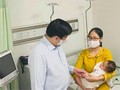 Bộ trưởng Bộ Y tế Nguyễn Thanh Long thăm em bé sau khi tiêm vaccine COVID-19 nhầm tại Trạm Y tế xã Yên Sơn, huyện Quốc Oai (Ảnh - Mạnh Cường)