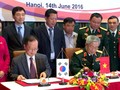 Thượng tướng Nguyễn Chí Vịnh (phải) và ông Chang Jae Yun ký kết biên bản hợp tác khắc phục hậu quả bom mìn sau chiến tranh - Ảnh: Q.TR..