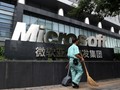 Một công nhân đi ngang qua văn phòng Microsoft tại Bắc Kinh (Ảnh: Bloomberg)