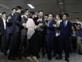 Ông Shin Dong Bin (giữa) trong vòng vây phóng viên sau khi hoàn toàn nắm quyền kiểm soát tập đoàn Lotte. Ảnh: AFP