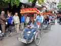 Du khách nước ngoài thăm phố cổ Hà Nội bằng xe xích lô. (Ảnh: Thanh Hà/TTXVN)