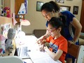 Phụ huynh trợ giúp con khi học trực tuyến - Ảnh: Hanoimoi.com.vn
