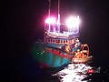 Xuồng cứu hộ của tàu SAR412 tiếp cận tàu cá, đưa ngư dân bị nạn về bờ trong đêm Ảnh MRCC