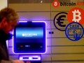 Một người đàn ông đi ngang qua một cây ATM bitcoin ở Vilnius, Litva. Ảnh: CNBC