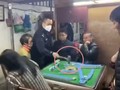 Người cảnh sát giận dữ dùng búa đập phá bàn mạt chược (Ảnh: Đông Phương)