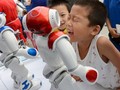 Những em bé đang nô đùa với robot trong một triển lãm ở Trung Quốc - Ảnh: Business Insider.