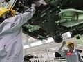 Công nhân làm việc trong phân xưởng lắp ráp ô tô.