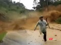 Người đi đường thất thần tháo chạy khỏi đống đất đá từ trên cao đổ xuống (ảnh cắt từ clip)
