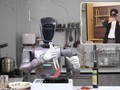 Robot hình người chế biến bít tết thông qua một người điều khiển từ khoảng cách 1.800 km. Ảnh: SCMP