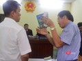 Họa sĩ Lê Linh (áo trắng) và ông Nguyễn Vân Nam (người đang cầm cuốn sách) - đại diện cho công ty Phan Thị với những trao đổi gay gắt tại tòa 