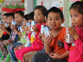 Các em nhỏ uống sữa tại trường mầm non.