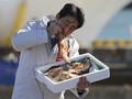 Ông Abe không ngần ngại ăn cá nướng tại tỉnh Fukushima. Ảnh: Reuters