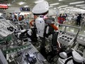 Robot làm việc cạnh con người trong dây chuyền lắp ráp tại một nhà máy của Glory, miền Bắc Tokyo (Nhật Bản) hôm 1/7/2015. Ảnh: Reuters