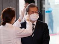 Tổng thống Hàn Quốc Moon Jae-in được đeo khẩu trang và kiểm tra thân nhiệt trước khi vào tòa nhà Quốc hội ở Seoul trong hôm 28/2 (Ảnh: Yonhap)