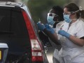 Nhân viên y tế tại một trạm iểm tra COVID-19 trên xe hơi ở London, Anh (Ảnh: EPA)