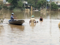 Người dân di chuyển bằng thuyền khi nước lũ dâng cao (Ảnh: Hồ Xuân Mai) 