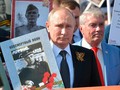 Tổng thống Nga V.Putin mang ảnh người Nga diễu hành cùng với Trung đoàn bất tử nhằm bảo vệ ký ức lịch sử về Ngày Chiến Thắng trong Chiến tranh giữ nước (Ảnh Sputnik)