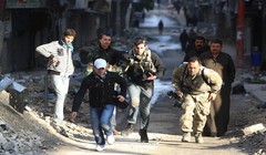 Các nhà báo mạo hiểm băng qua một con đường trong thành phố đang có chiến sự Aleppo ở Syria năm 2012 - Ảnh: Reuters