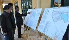 Người dân xã Phù Đổng, Trung Mầu (huyện Gia Lâm) xem bản quy hoạch nhà máy nước mặt sông Đuống. Ảnh: TTXVN