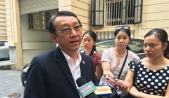 Ông Huỳnh Tấn Vinh trao đổi với cơ quan báo chí bên ngoài hành lang buổi tọa đàm. Ảnh - Quang Vững