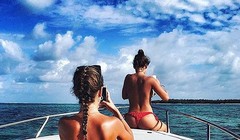 Hai cô gái Nga chụp ảnh trong bộ bikini của họ trong khi trên một thuyền buồm du thuyền trên đại dương trong một kỳ nghỉ nhiệt đới