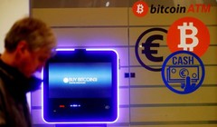 Một người đàn ông đi ngang qua một cây ATM bitcoin ở Vilnius, Litva. Ảnh: CNBC