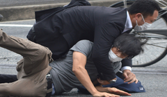 Lực lượng an ninh khống chế nghi phạm Tetsuya Yamagami (áo xám) tại hiện trường vụ nổ súng (Ảnh: AFP)