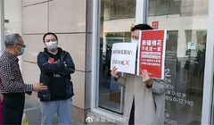 Một người mang biểu ngữ tẩy chay H&M đứng chắn trước một cửa hàng của thương hiệu này ở Hồ Nam (Ảnh: Đa Chiều).