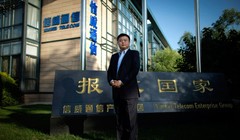 Vương Tịnh đứng trước trụ sở Tập đoàn Xinwei với Slogan "Báo hiếu quốc gia" (Ảnh: Sina)