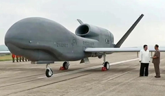 Nhà lãnh đạo Kim Jong-un trao đổi với quan chức hữu quan trước khi chiếc UAV bay thử nghiệm. Ảnh: Guancha.