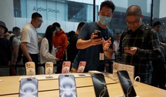 Một nhân viên của Apple Store đang phục vụ khách hàng khi dòng điện thoại thông minh iPhone 16 mới được bán tại Bắc Kinh. ẢNh: SCMP.