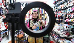 Chủ một cửa hàng bán tất ở Thành phố Thương mại Quốc tế Nghĩa Ô sử dụng AI để tạo video giới thiệu sản phẩm. Ảnh: China News Service.