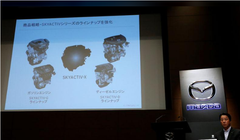 Chủ tịch hãng Mazda Masamichi Kogai bên cạnh màn hình giới thiệu động cơ mới tại cuộc họp báo ở Tokyo ngày 8/8. Ảnh Reuters