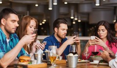 Cảnh tượng quen thuộc: Ngồi cạnh nhau nhưng mỗi người đều chỉ nhìn vào màn hình điện thoại.  Dreamstime/TNS