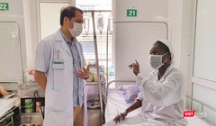 Bác sĩ Trung tâm Bệnh nhiệt đới Bệnh viện Bạch Mai trò chuyện, động viên bệnh nhân bị sốt rét ác tính trong những ngày điều trị (ảnh BV cung cấp)