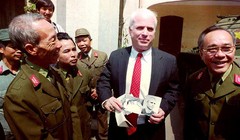 2-	Thượng nghị sỹ John McCain cầm những tấm hình đen trắng chụp ông khi bị bắt làm tù binh ở Hà Nội năm 1967 trong một chuyến đến thăm Bảo tàng quân đội nhân dân Việt Nam ngày 9/10/1992.Ảnh: Hoàng Đình Nam/ AFP.