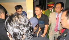 Bà Châu Thị Thu Nga (giữa, chụp mũ) bị bắt giữ và dẫn giải về trại giam vào tối khuya 7-1