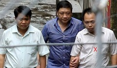 Thiếu tướng Chung (trái) cùng Bình (ngoài cùng bên phải) ra xe về trụ sở công an