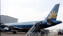 Hành khách lên máy bay của Vietnam Airline tại sân bay quốc tế Tân Sơn Nhất. Ảnh: Hoàng Hải - TTXVN