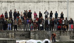 Một thanh niên thực hiện nghi thức tang lễ cho một người thân thiệt mạng vì động đất bên bờ sông ở Kathmandu. Ảnh: Reuters