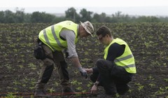 Các nhà điều tra quốc tế xem xét bằng chứng tại hiện trường vụ rơi máy bay MH17 - Ảnh: Reuters