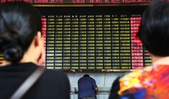 Nhà đầu tư Trung Quốc đang theo dõi bảng điện tử. Ảnh:ChinaFotoPress