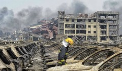 Lính cứu hỏa đi giữa các phương tiện bị phá hủy trong vụ nổ hôm 12/8. Ảnh: Reuters