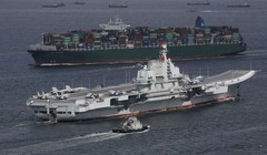 Tàu sân bay Liêu ninh trên nền một chiếc tàu vận tải lớn của Trung Quốc